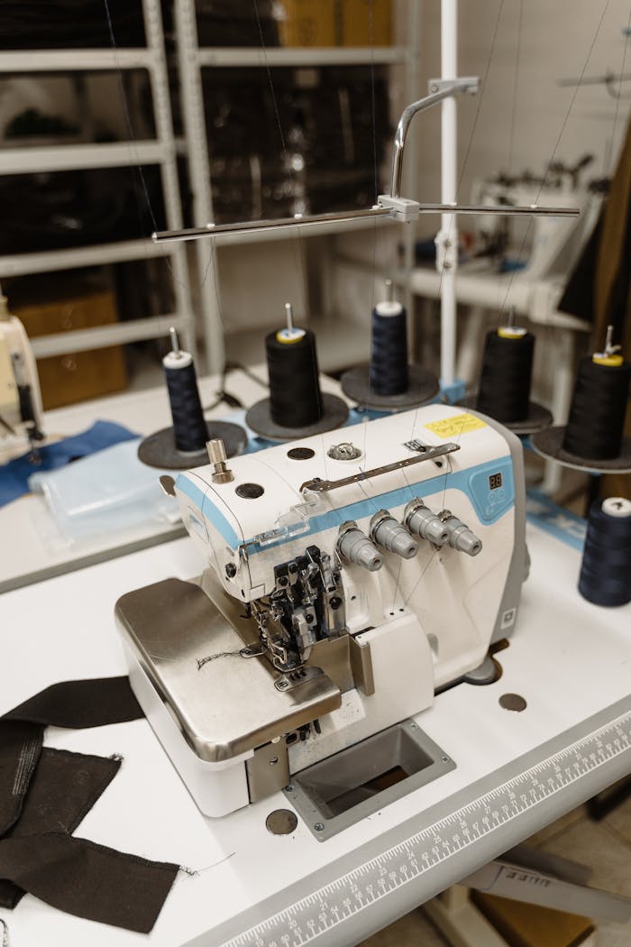 Industrial sewing machine in a modern clothing workshop, showcasing textile production.